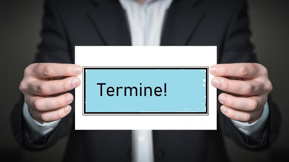 Mann hält Schild "Termine"